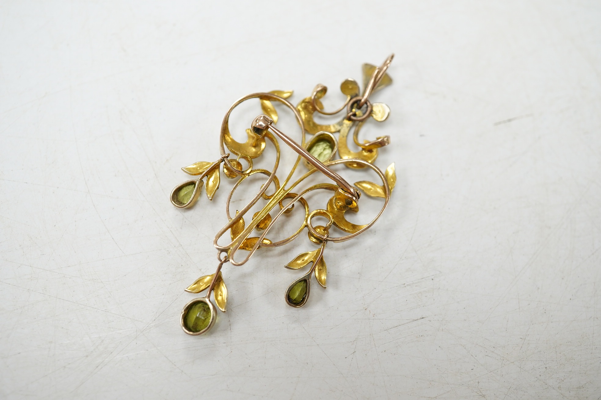 An early 20th century 9ct, peridot and seed pearl cluster set drop pendant brooch, 53mm, gross weight 5 grams. Condition - fair